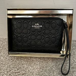 Brand new with tags and box Coach wristlet. Black with shimmering black logo C’s
